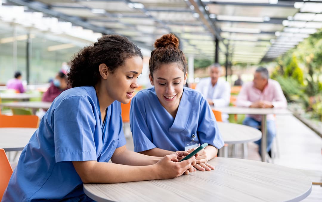 Two nurses looking at phone